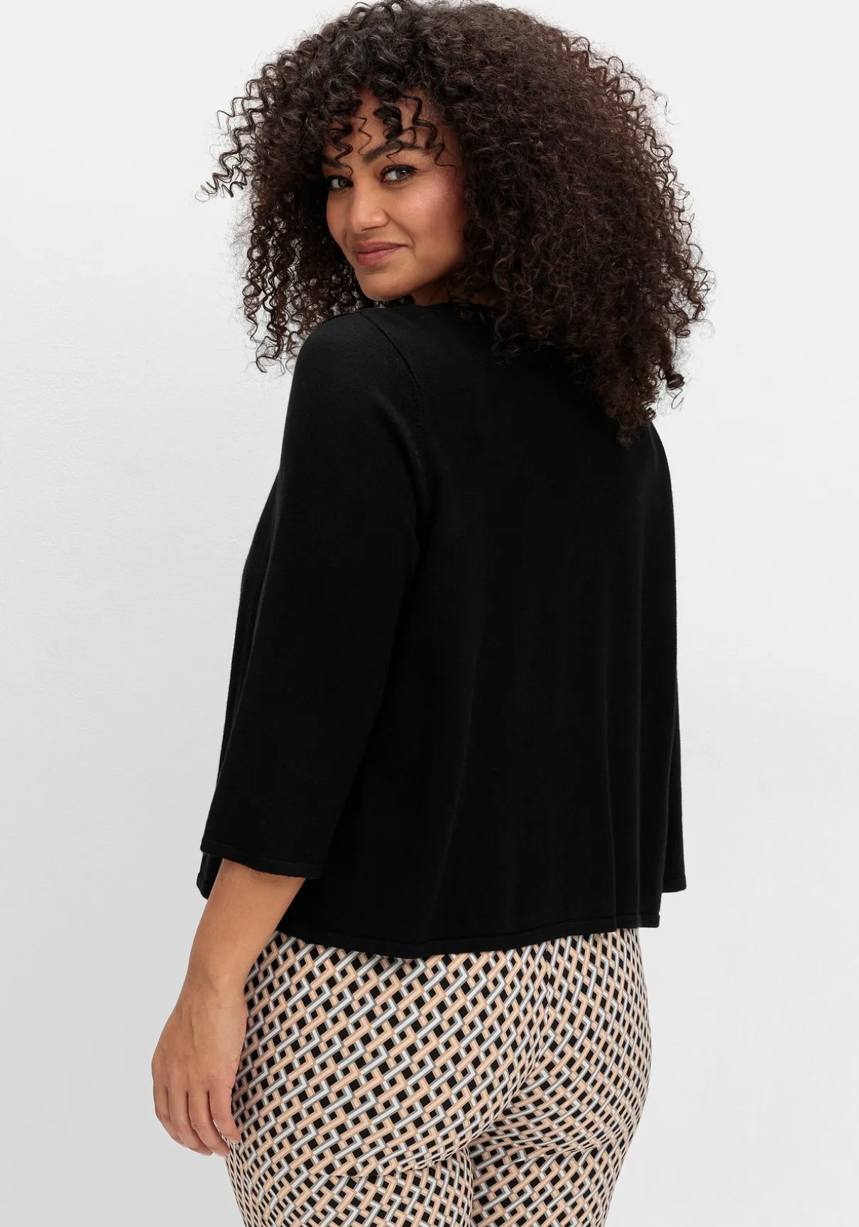 Kurze Strickjacke mit Zierspange am Ausschnitt